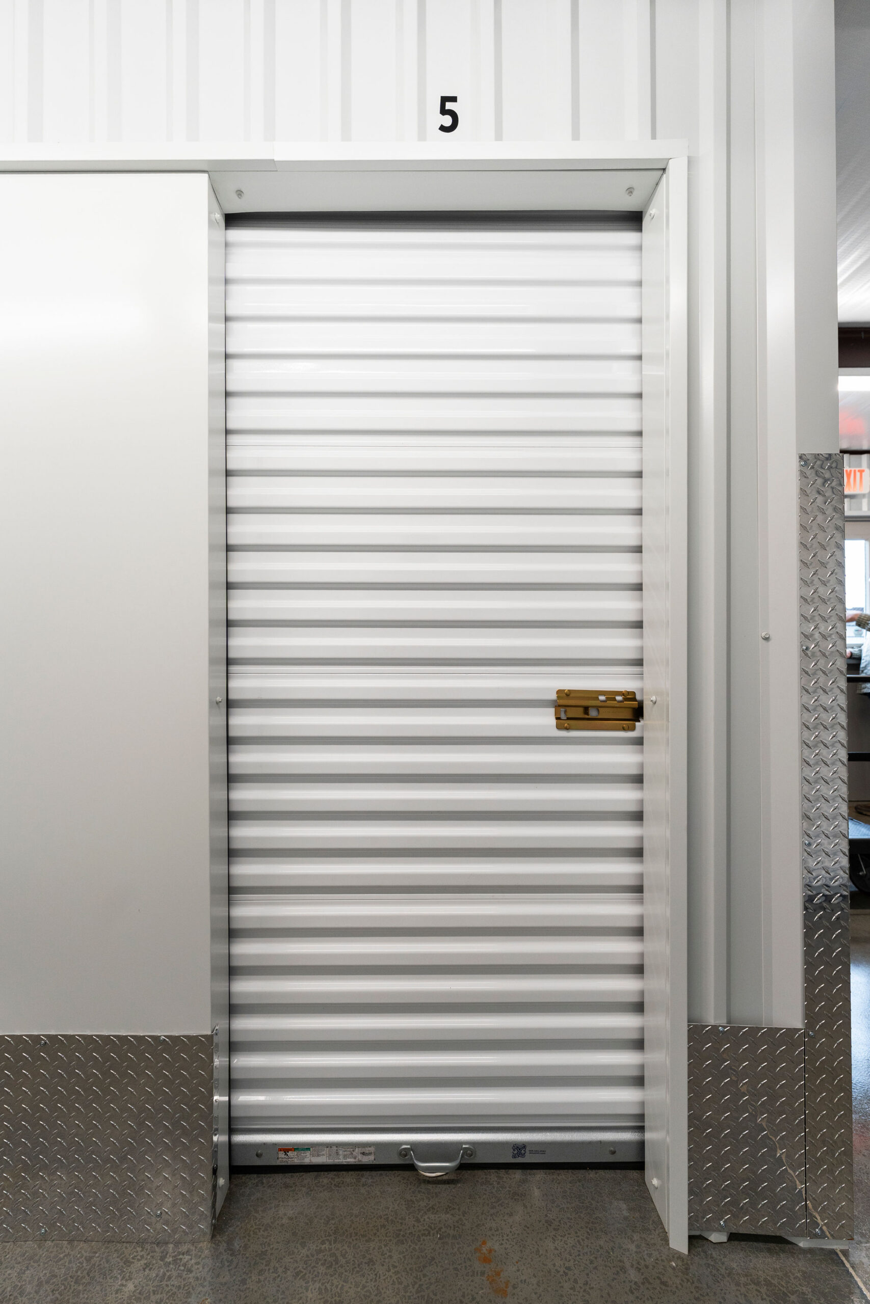 Indoor storage unit number 5 with a white roll-up door