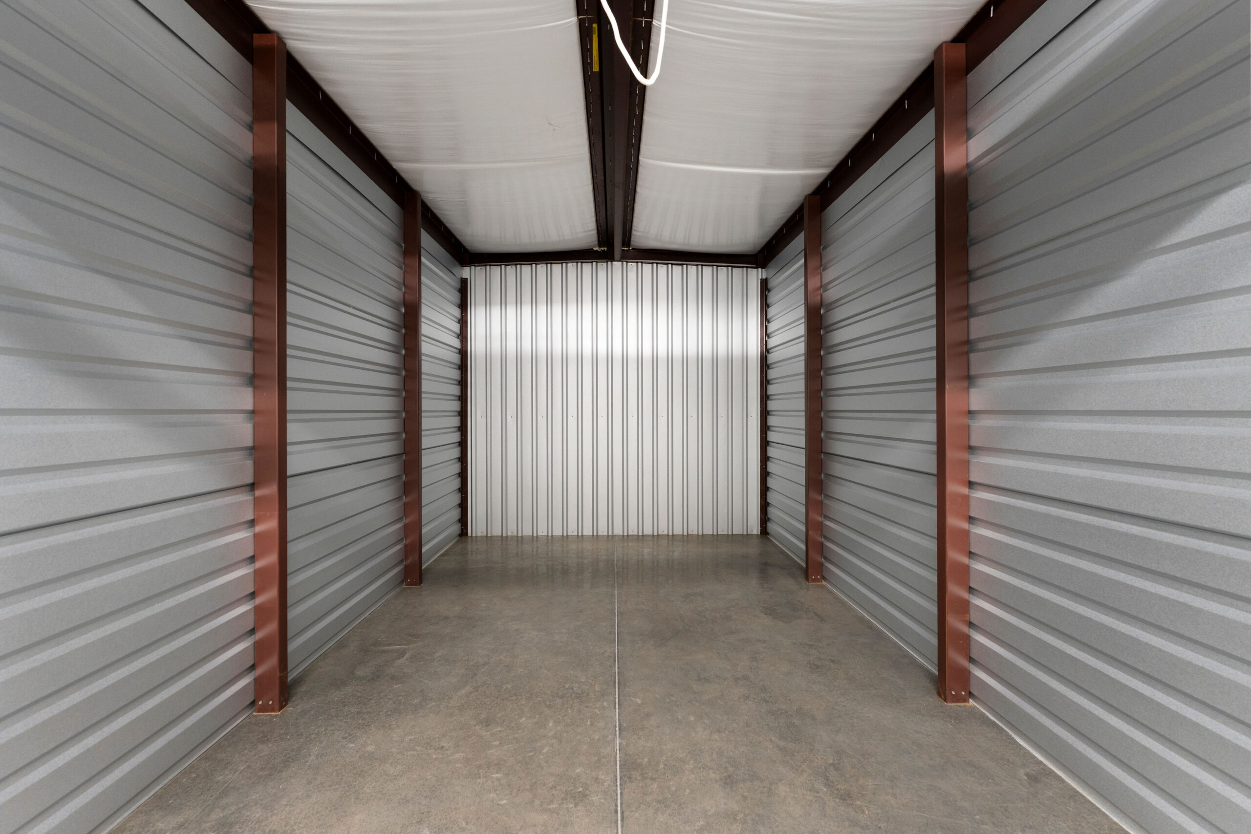 Empty interior of a storage unit with metal walls and concrete floor